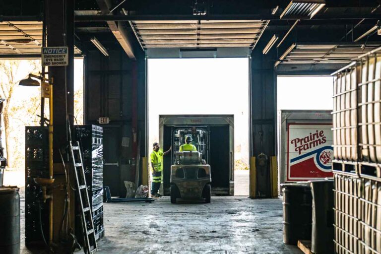 worker driving forklift into truck
