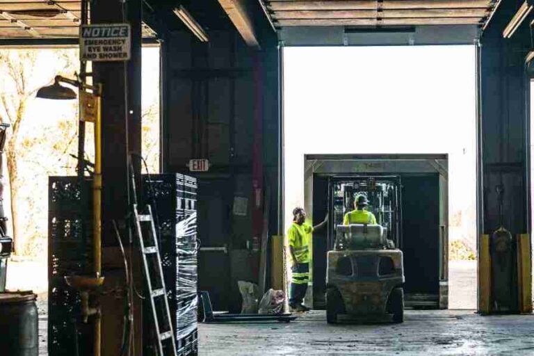 worker driving forklift into truck