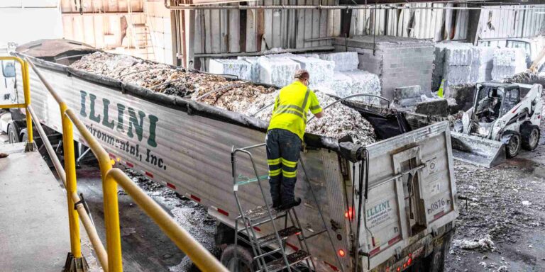 worker loading waste truck